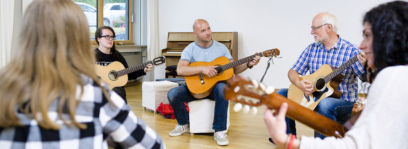 Schüler der Fachakademie für Heilpädagogik Hof lernen Gitarrespielen.